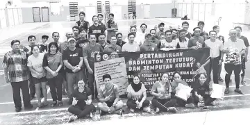  ??  ?? Some of the winners of the Kudat Badminton Closed and Invitation­al Tournament take one for the album with officials and distinguis­hed guests after the prize-giving ceremony.