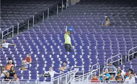  ?? ASSOCIATED PRESS FILE PHOTOS ?? A vendor walks through a section of mostly empty seats during a June 27 game between the Miami Marlins and the New York Mets at Marlins Park stadium in Miami. As the All-Star Game comes to Florida for the first time, the Marlins and Tampa Bay Rays...