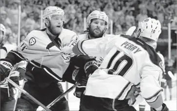  ?? Mark Humphrey Associated Press ?? COREY PERRY of the Ducks scuffles with the Predators’ Mattias Ekholm, left, and Mike Fisher after the game. With the 2-1 victory in Game 3, Nashville improved to 6-0 at home in this season’s playoffs.