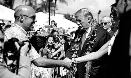  ?? ANDREW HARNIK/AP ?? President Donald Trump and first lady Melania Trump don leis as they arrive at Joint Base Pearl Harbor-Hickham, Hawaii.