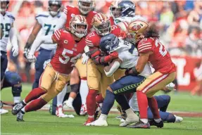  ?? KYLE TERADA/USA TODAY SPORTS ?? The 49ers’ Fred Warner (54), Azeez Al-Shaair (51) and Talanoa Hufanga (29) tackle Seahawks running back Rashaad Penny.