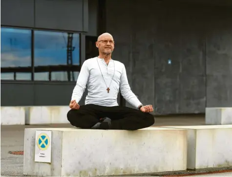  ?? Foto: Marcus Merk ?? Vor dem Gefängnis in Gablingen zeigt Pfarrer Peter Trapp eine seiner Yogaübunge­n. Der Seelsorger gibt dazu auch hinter Gittern Kurse.