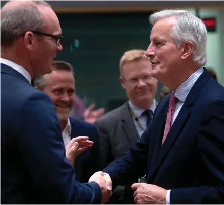  ??  ?? EU chief Brexit negotiator Michel Barnier shakes hands with Foreign Minister Simon Coveney during a meeting at the European Council headquarte­rs in Brussels.