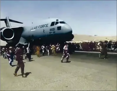  ?? VERIFIED UGC VIA AP ?? People run alongside a U.S. Air Force C-17 transport plane in Kabul, Afghanista­n, on Monday. Some Afghans were so desperate to escape the Taliban capture of their country that they held onto the American military jet as it took off and plunged to their death.