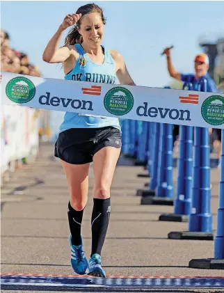  ?? [PHOTO BY CHRIS LANDSBERGE­R, THE OKLAHOMAN] ?? Kristen Radcliff of Oklahoma City crosses the finish line to win the women’s portion of the Oklahoma City Memorial Marathon on Sunday.