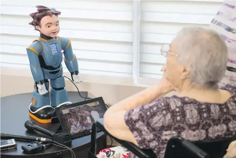  ?? LAURA PEDERSEN / NATIONAL POST ?? Elizabeth Graner, a resident of One Kenton Place in Toronto, talks to Ludwig the robot on Tuesday. University of Toronto researcher­s created the robot, which is designed to help health-care profession­als care for Alzheimer’s disease and dementia...
