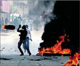  ?? PHOTO: FLASH 90 ?? West Bank protesters throw burning tyres during last year’s Nakba Day