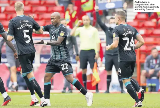  ??  ?? Andre Ayew is congratula­ted after slotting home a penalty at the City Ground