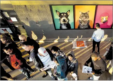  ?? AP ?? Shoppers line up in front of an adjacent pet store as they wait for a Best Buy store to open for an early Black Friday sale on Thanksgivi­ng Day in Overland Park, Kan.