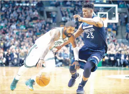  ?? /AP PHOTO ?? ■ LUSOT. Nangita’g paagi si Boston Celtics guard Kyrie Irving (11) aron malutsan ang depensa ni Jimmy Butler sa Minnesota Timberwolv­es ning aktuha sa 2nd quarter sa ilang sangka kagahapon sa NBA.