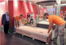  ??  ?? The Acropolis Museum’s president, Dimitrios Pandermali­s (left), watches workers set down a box in the exhibition space that was specially designed for this show.