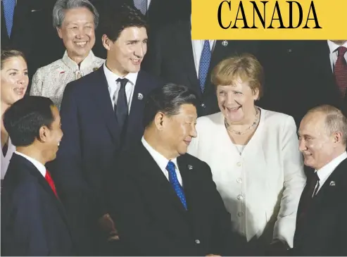  ?? Adrian Wyld / the canadian pres ?? Sophie Trudeau, Prime Minister Justin Trudeau, German Chancellor Angela Merkel, Indonesian President Joko Widodo, front left, Chinese President Xi Jinping and Russian President Vladimir Putin share a laugh as they wait for a photo at the G20 Summit in Osaka, Japan, on Friday.