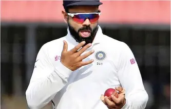  ?? AIJAZ RAHI AP ?? INDIA’S captain Virat Kohli shines the ball during a cricket test match.
|