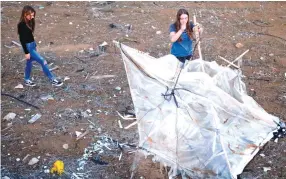  ?? (Amir Cohen/Reuters) ?? ISRAELI TEENS Meshy Elmkies (R), 16, and Lee Cohen, 17, co-managers of the Instagram account Otef.Gaza, show Reuters journalist­s an incendiary kite launched from the Gaza Strip, during an interview last month in Kibbutz Kerem Shalom.