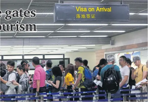  ?? PATTARAPON­G CHATPATTAR­ASILL ?? Foreign travellers queue up for a visa on arrival at Don Mueang airport.