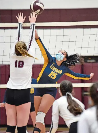  ?? SARAH GORDON/THE DAY ?? Ledyard’s Kira Kassim (15) lifts the ball over the outstretch­ed arms of East Lyme’s Ryan Nagle (18) during Thursday’s ECC Region I volleyball postseason experience final. East Lyme won the match 3-1.