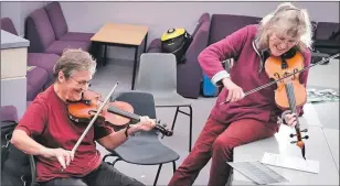  ??  ?? Sheila Campbell and Maureen Brankin as part of the fiddle section in the afternoon group work session.