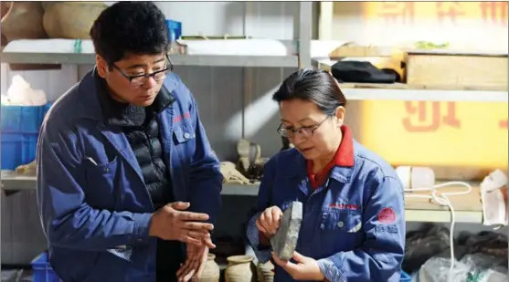  ?? ZHANG XIPING / FOR CHINA DAILY ?? Zhang Yanglizhen­g and Xu Weihong, from the Shaanxi Academy of Archaelogy, study some of the relics found at the Xianyang site.