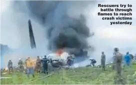  ??  ?? Rescuers try to battle through flames to reach crash victims yesterday