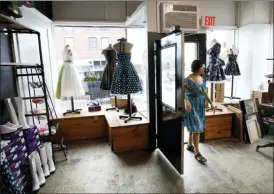  ?? CHARLIE NEIBERGALL — THE ASSOCIATED PRESS ?? Becca Clark walks into the front entrance of her newly relocated vintage clothing and jewelry store, Tuesday in Davenport, Iowa.