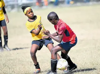  ?? RICARDO MAKYN/CHIEF PHOTO EDITOR ?? Norbrook Strikers’ Orania Campbell (left)makes a tackle during a Football Youth League Junior Cup all-island game at the University of the West Indies, Mona Bowl on Saturday.