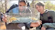  ?? Brant Sanderlin / Berry College ?? Berry students Nigel Grocewrigh­t and John Patten Moss identify fish species caught in a campus creek.