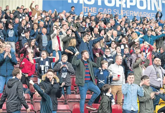  ??  ?? A large Dundee support got right behind their team as they battled to victory against Motherwell at Fir Park.