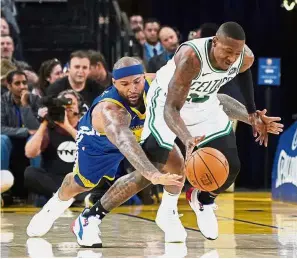  ?? — Reuters ?? Going all out: Boston Celtics guard Terry Rozier (right) dribbling past Golden State Warriors centre DeMarcus Cousins during the NBA game at the Oracle Arena on Tuesday.