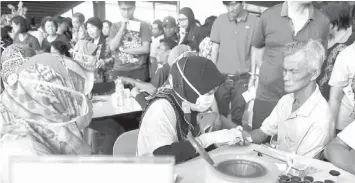  ?? — Bernama photo ?? EAGER: Participan­ts queuing up to get their free health checks at the World Diabetes Day celebratio­n at KTS Garden.