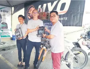  ??  ?? ISTIMEWA: Lim (kanan) bersama Tan (tengah) berposing dengan minyak pelincir keluaran HYO bersama hadiah-hadiah menarik yang menanti pelanggan cabutan bertuah memenangin­ya.