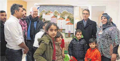  ?? FOTO: ANNA KRATKY ?? Das fünfte Türchen des LEA-Adventskal­enders zeigt Ellwangen aus Linsen, Papier und Zweigen. „Großartig und beeindruck­end“findet Klaus Danner (Erster links neben dem Bild), neuer Ombudsmann für die Flüchtling­serstaufna­hme in BW, den Kalender.