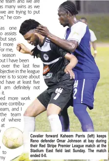  ??  ?? Cavalier forward Kaheem Parris (left) keeps Reno defender Omar Johnson at bay during their Red Stripe Premier League match at the Stadium East field last Sunday. The match ended 0-0.