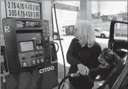  ?? DANA JENSEN/THE DAY ?? Barbara Klein of New Haven watches the price screen while she pumps gas Thursday at Citgo on Williams Street in New London.