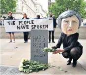  ??  ?? Activists Avaaz caricature Theresa May laying flowers on the tombstone of hard Brexit, above. Right: Mrs May on the stump