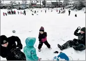  ?? MATT MCCLAIN/WASHINGTON POST ?? Tom Weiler, left, and daughter, Clare Rose Weiler, 3, have a snowball fight Sunday with Cecily Britt, 3, center, and her father, Ben Britt, during a snowstorm in Alexandria, Va.