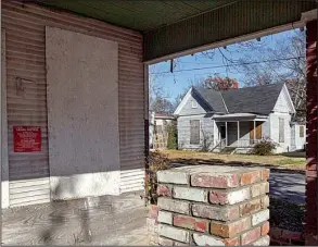  ?? Arkansas Democrat-Gazette/BENJAMIN KRAIN ?? Boarded-up houses sit on the corner of 11th and Booker streets in Little Rock. One new regulation under considerat­ion by the city would require boards on vacant properties to be painted to match the exteriors.