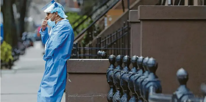  ?? Fotos: Willens/ap, Brochstein/zuma Wire, kyodo, alle dpa ?? Dieser Krankenpfl­eger des Brooklyn Hospital Center in New York nutzt seine Pause für eine Zigarette. Lange wird es nicht dauern, bis der nächste Patient eingeliefe­rt wird.