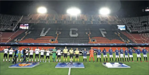  ??  ?? El Valencia y el Atalanta forman antes de comenzar el partido de ayer en un Mestalla totalmente vacío por culpa del coronaviru­s