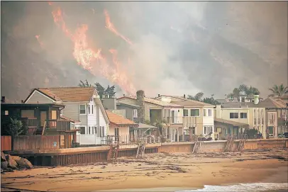  ??  ?? Flames threaten homes along the Pacific Ocean between Solimar and Faria Beaches, north of downtown Ventura, on Wednesday.