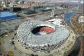  ?? PHOTOS BY YANG FEIYUE / CHINA DAILY ?? Left: The tourism helicopter flies over the Bird’s Nest, the main venue of the 2008 Beijing Olympic Games. tourism flight offers unique views of Beijing. Right: The new low-altitude