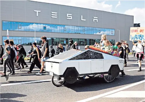  ?? ?? Car trouble Young protesters ride in a mocked-up Cybertruck during a demonstrat­ion against an expansion of the Tesla factory in Gruenheide, Germany. Activists are trying to stop an expansion of the American electric-car maker’s facilities that could mean razing part of a surroundin­g forest.