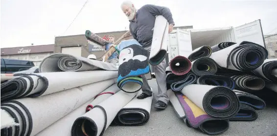  ?? ADRIAN LAM, TIMES COLONIST ?? Stephen (Dusty) Roberts, right, and Ethan Taillefer-Meyn of Luv-A-Rug prepare clean rugs for loading and return to elementary schools.