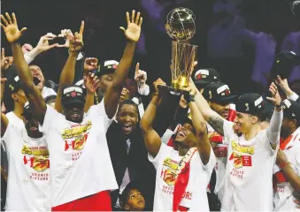  ?? LACHLAN CUNNINGHAM/GETTY IMAGES FILES ?? The Toronto Raptors celebrate with the Larry O’brien Trophy a year ago after beating the Golden State Warriors in Game 6 of the NBA Finals in Oakland, Calif.