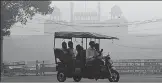  ?? AFP ?? ▪ An electric rickshaw passes the Red Fort in New Delhi on Friday