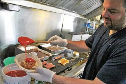  ?? LAUREN HALLIGAN -- LHALLIGAN@DIGITALFIR­STMEDIA.COM ?? Albert Deeb of Little Big Fatz Food Shack prepares a slider inside the food truck.