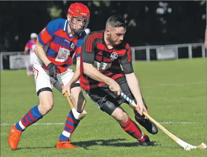  ?? Photograph: Kevin McGlynn. ?? Oban Camanachd’s Malcolm Clark, who scored two goals for the red and blacks, takes on Kingussie’s Evan Michie during last Saturday’s Marine Harvest premiershi­p encounter at Mossfield Stadium.