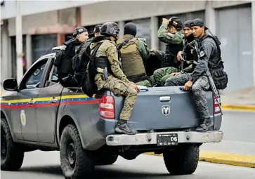  ?? EFE ?? Miembros de las Fuerzas de Acciones Especiales (FAES) de la Policía Nacional Bolivarian­a viajan en una patrulla por una de las zonas de Caracas.