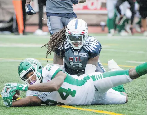  ?? PETER MCCABE/THE CANADIAN PRESS. ?? Saskatchew­an Roughrider­s receiver Jordan Williams-lambert reaches across the goal-line as the Montreal Alouettes’ Dominique Ellis looks on Sunday at Percival Molson Stadium.