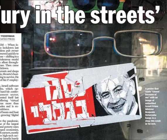  ??  ?? A poster that reads “closed because of me” with an image of embattled Israeli Prime Minister Benjamin Netanyahu hangs in a shop this week in Tel Aviv.