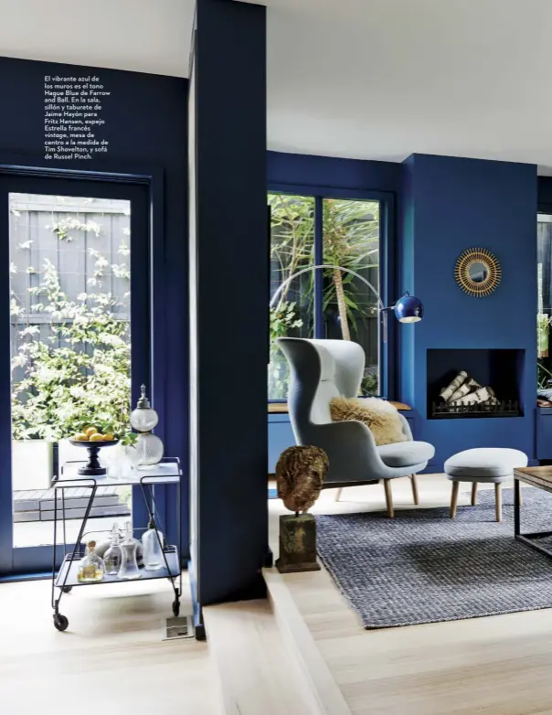  ??  ?? El vibrante azul de los muros es el tono Hague Blue de Farrow and Ball. En la sala, sillón y taburete de Jaime Hayón para Fritz Hansen, espejo Estrella francés
vintage, mesa de centro a la medida de Tim Shovelton, y sofá de Russel Pinch.